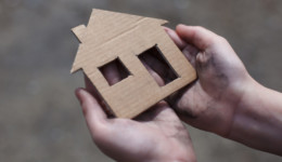 homeless boy holding a cardboard house